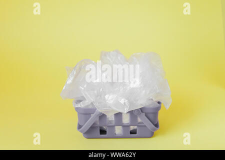 Polyäthylenbeutel im Warenkorb auf gelben Hintergrund. Stockfoto