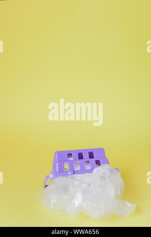 Polyäthylenbeutel im Warenkorb auf gelben Hintergrund. Stockfoto