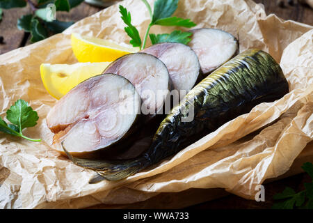 Kalt geräucherter Makrele Fisch auf einem Pergament Papier mit Petersilie und Zitrone Keile Stockfoto