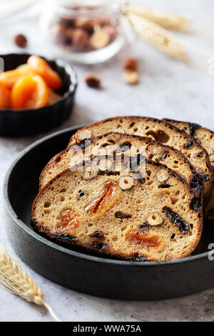 Scheiben Roggenbrot mit Haselnüssen und getrockneten Obst wie Aprikosen, Rosinen und Pflaumen Stockfoto