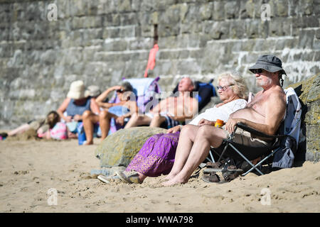 Menschen Sonnen bei Barry Island, Vale von Glamorgan, Wales, wo Strand - goers haben, den Sand, die die meisten der heißes Wochenende Wetter in Großbritannien zu machen. Stockfoto