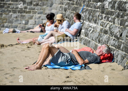 Menschen Sonnen bei Barry Island, Vale von Glamorgan, Wales, wo Strand - goers haben, den Sand, die die meisten der heißes Wochenende Wetter in Großbritannien zu machen. Stockfoto