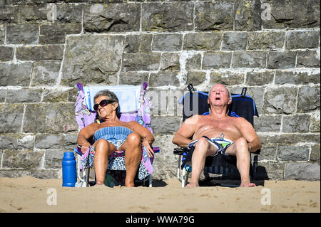 Menschen Sonnen bei Barry Island, Vale von Glamorgan, Wales, wo Strand - goers haben, den Sand, die die meisten der heißes Wochenende Wetter in Großbritannien zu machen. Stockfoto