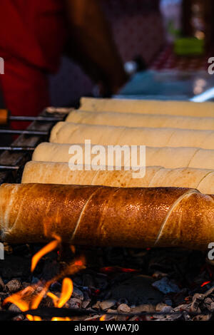 Vorbereitung auf die berühmten, traditionellen und leckeren ungarischen Schornstein Kuchen Kurtos Kolacs (Kürtőskalács) Stockfoto