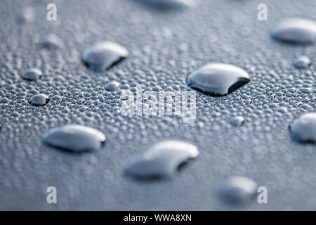 Wassertropfen auf eine schwarze Fläche. Makroaufnahme. Stockfoto