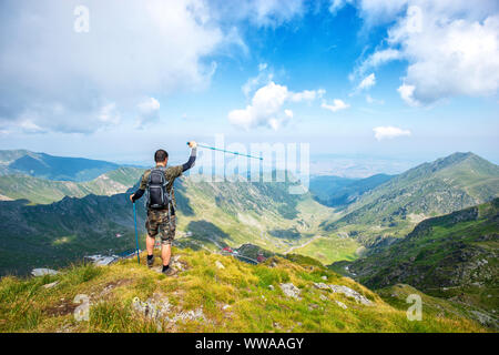 Erfolgreiche aktive Mann Wanderer auf oben auf den Berg und die Aussicht genießen. Reisen Sport Lifestyle Konzept Stockfoto
