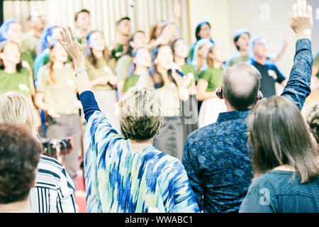 Die Menschen in der Kirche, Gott anzubeten, mit den Händen auf. Stockfoto