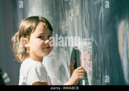 Schöne Mädchen Zeichnung auf einer Tafel am Spielplatz Stockfoto