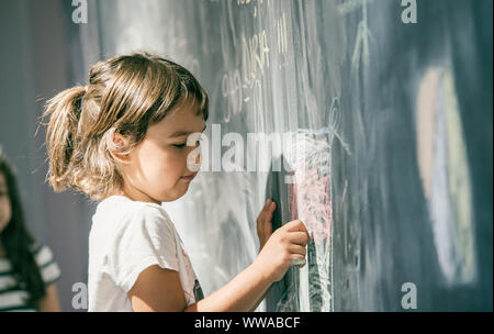 Schöne Mädchen Zeichnung auf einer Tafel am Spielplatz Stockfoto