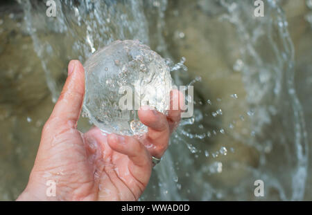 Wasser fallen auf der lansball Holding in der Hand Stockfoto