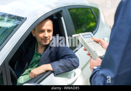 Treiber an, da der Betreff für Alkoholgehalt mit Verwendung von breathalyser zu testen Stockfoto