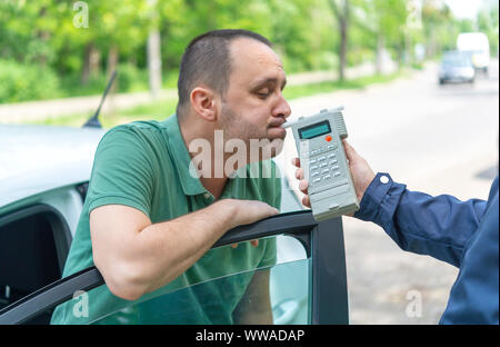 Treiber an, da der Betreff für Alkoholgehalt mit Verwendung von breathalyser zu testen Stockfoto