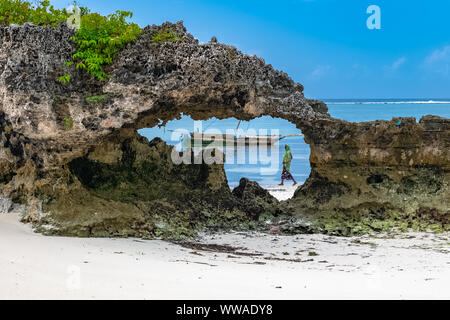 Sansibar in Tansania, typische Fischerboot an einem wunderschönen Strand mit Wellen Stockfoto