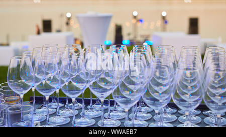 Viel Wein Gläser in einer Reihe. Luxus Gläser für Alkohol. Wein Gläser mit Wein an einem Tisch draußen. Stockfoto