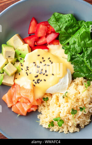 Pflanzliche buddha Schüssel mit Lachs, Fetakäse und Couscous, Spinat, Avocado, Tomaten, Ansicht von oben. Gesunde Ernährung Konzept Stockfoto