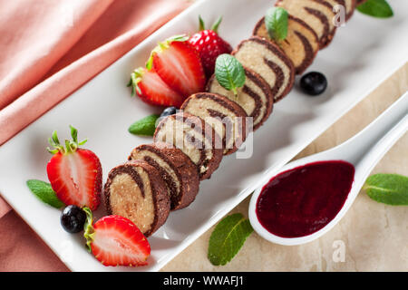 Spirale cookies mit frischen Erdbeeren und Beeren Sauce Stockfoto