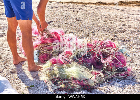 Ein kabelsalat Fischernetze Kunststoff Seil und andere Ablagerungen auf einer Küste Strand gespült. Speichern Sie die Planeten stock Bild. Stockfoto