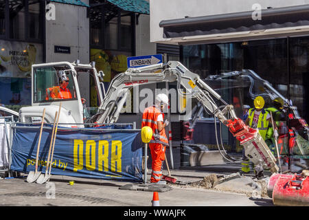 Arbeitnehmer mit mechanischen Bagger Graben in Stadt Straße graben - Wien, Österreich. Stockfoto