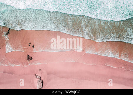 Luftaufnahme von Wellen und Schöne rosa Sandstrand Küste Stockfoto