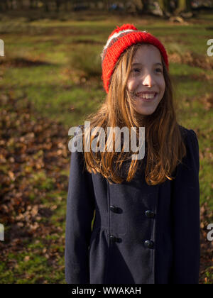 9 Jahre alte Mädchen mit einem bobble Hut auf einem herbstlichen Spaziergang in Cheshire, Großbritannien Stockfoto