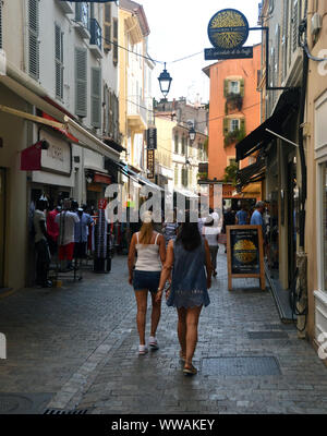 Zwei junge Mädchen zu Fuß durch die engen Einkaufsstraße Rue Meynadier in der Altstadt von Cannes, Cote d'Azur, Frankreich, EU. Stockfoto