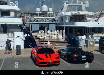 Sportwagen durch die Luxusyacht auf der Mole im Hafen von Cannes, Cote d'Azur, Frankreich, EU geparkt. Stockfoto