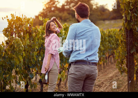 Lächelnd ein paar Trauben gemeinsam die Ernte in einem Weinberg Stockfoto