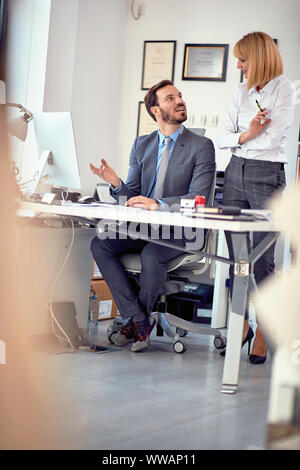 Lächelnd Geschäftsmann im Büro mit Mitarbeitern Stockfoto