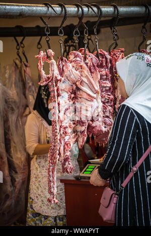 Xian, China - Juli 2019: Frau kaufen Schaf und Kuh Tierkörperfleisch vom Street Food Anbieter Shop im muslimischen Viertel von Xian Stadt muslimische, Shaanxi Stockfoto