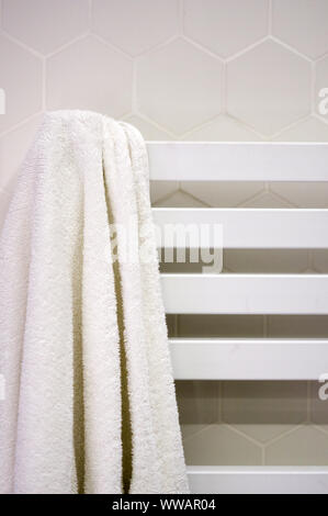 Moderne beheizte Handtuchhalter hängend auf Marmor gefliestes