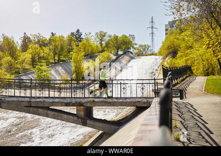 Mann mit dem grauen Bart, der auf der Brücke über den Fluss am Morgen. Gesunder Lebensstil Konzept Stockfoto