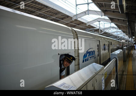 Tokio/Japan - 7. August 2019 - Die Wache des Shinkansen von Tokio nach Kyoto sieht aus dem Fenster, als er fährt die Station Stockfoto