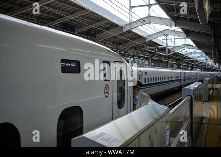 Tokio/Japan - 7. August 2019 - Die Wache des Shinkansen von Tokio nach Kyoto sieht aus dem Fenster, als er fährt die Station Stockfoto