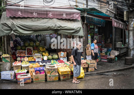 Xian, China - Juli 2019: Müde alte Mann, der vor einem Obst- und Gemüse im muslimischen Viertel in Xian, Provinz Shaanxi Stadt Abschaltdruck Stockfoto