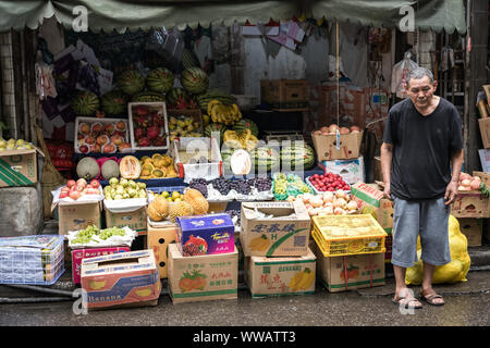 Xian, China - Juli 2019: Müde alte Mann, der vor einem Obst- und Gemüse im muslimischen Viertel in Xian, Provinz Shaanxi Stadt Abschaltdruck Stockfoto