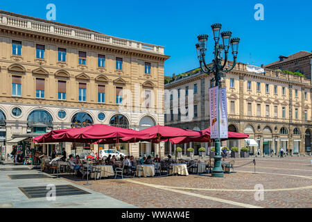 Leute genießen Mittagessen in einem Restaurant auf der Piazza San Carlo, einem der wichtigsten Plätze der Stadt, umgeben von eleganter barocker Architektur, Turin, Italien Stockfoto