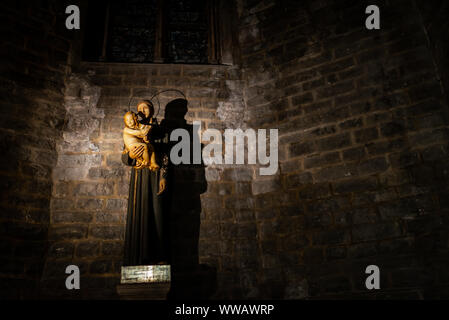Statue der Heiligen und einem Kind unter einem Suchscheinwerfer in der Basilika Santa Maria del Mar, Barcelona, Spanien Stockfoto