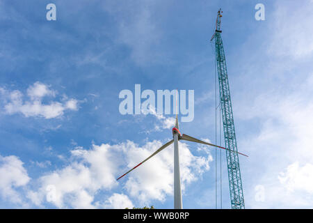 Eine große Windparks mit vielen Windkraftanlagen in der Nähe einer kleinen Stadt in Norddeutschland gebaut Stockfoto