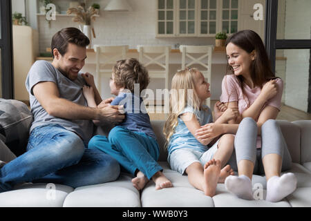 Freudige Familie von vier genießen Spaß auf bequemen Couch. Stockfoto