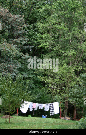 Wäsche aufhängen auf einfache Wäscheleine im Hof Stockfoto