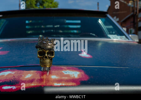 WROCLAW, Polen - 11. August 2019: USA Autos zeigen-metallischen Schädel mit einer Krone auf die Motorhaube des Autos Cadillac DeVille. Close-up. Stockfoto