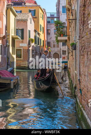 Venedig, Italien, 20. April 2019: Kanal mit Gondeln und historische Häuser eng, in einer schönen, sonnigen Tag. Stockfoto