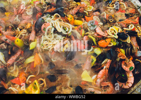 Paella mit Meeresfrüchten ist in eine große Kapazität gekocht. Große Stockfoto