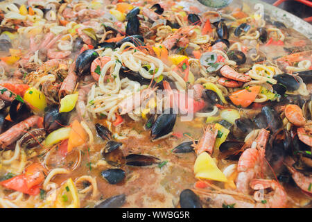 Paella mit Meeresfrüchten ist in eine große Kapazität gekocht. Große Stockfoto