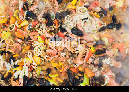 Paella mit Meeresfrüchten ist in eine große Kapazität gekocht. Große Stockfoto
