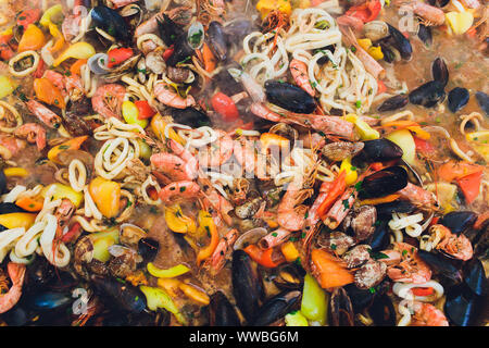 Paella mit Meeresfrüchten ist in eine große Kapazität gekocht. Große Stockfoto