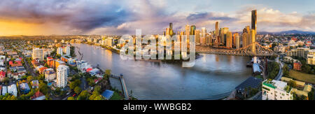 Bunte sunrise Mit stürmischem Wetter über Brisbane CBD hinter der Story Bridge in Brisbane River in hohen Breiten Antenne Panorama. Stockfoto