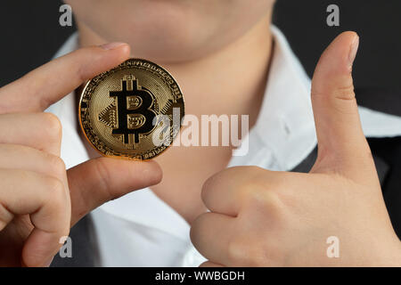 Eine Bitcoin in der Hand des Jungen. Konzept. Stockfoto