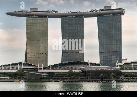 Singapur - März 20, 2019: Marina Bay Sands Hotel und Casino mit seinen drei Türmen von hinter der Bucht unter Licht cloudscape gesehen. Stockfoto