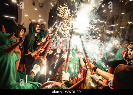 Sitges, Spanien. 14 September, 2019: 'Correfocs' (Feuer Läufer) erleuchten Ihren stick Feuerwerk während Sitges Festival Santa Tecla montiert. Credit: Matthias Oesterle/Alamy leben Nachrichten Stockfoto